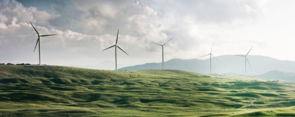 Windräder auf grünen Hügeln